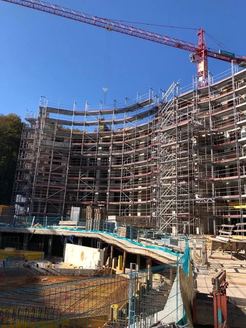 Baustelle einer Überbauung mit Gerüst und Kran