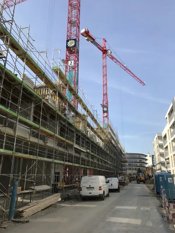 Baustelle mit Fassadengerüst und Kranen